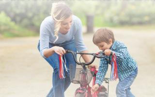 Mom helping son on bike